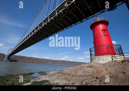 USA, New York, New York City, Jeffrey's Hook Light ou peu phare rouge ci-dessous George Washington Bridge sur la rivière Hudson avec ciel bleu au-dessus Banque D'Images