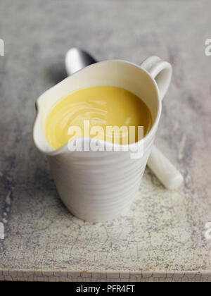 Petit pot contenant de sauce hollandaise Banque D'Images