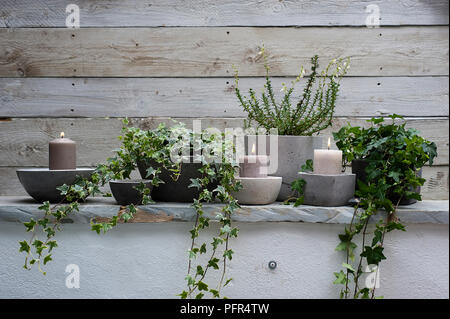 Des bougies et des plantes en pots en béton disposés sur Vire Banque D'Images