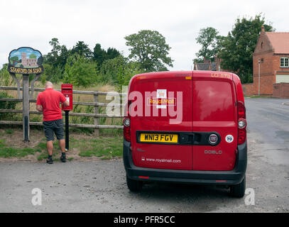 Un postier de vider une boite aux lettres, Stanford-sur-Soar, Nottinghamshire, Angleterre, RU Banque D'Images