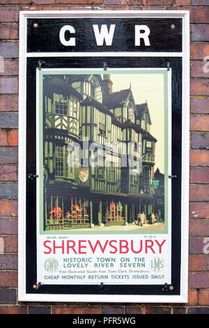 Voyage d'époque, affiche de chemin de fer GWR en plein air à la gare sur la ligne de chemin de fer du patrimoine, Royaume-Uni, annonçant la ville historique de Shrewsbury. Banque D'Images