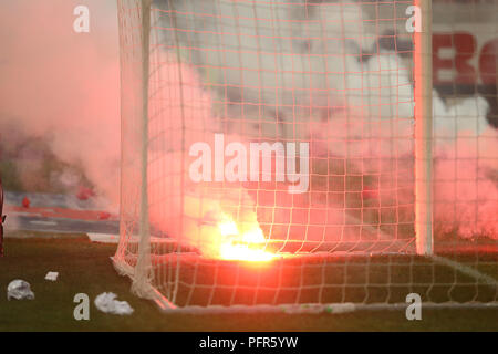 Bucarest, Roumanie - 28 juillet 2018 : Pompier tente d'éteindre les torches jetées sur l'herbe par le Dinamo Bucarest supporters Banque D'Images