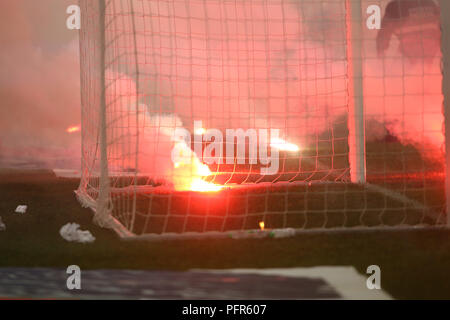 Bucarest, Roumanie - 28 juillet 2018 : Pompier tente d'éteindre les torches jetées sur l'herbe par le Dinamo Bucarest supporters Banque D'Images