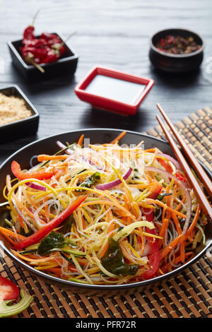 Style asiatique-léger et frais en tranches avec une salade de légumes croquants et d'algues wakame Vue de dessus de nouilles de riz dans un bol, close-up, vue d'en haut Banque D'Images