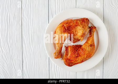 Cuisses de poulet frit croustillant sur une plaque blanche sur une table en bois, télévision lay, close-up,Vue de dessus Banque D'Images