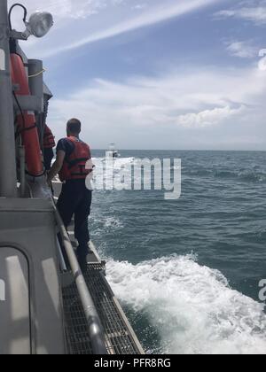 Garde côtière canadienne Maître de 2e classe Josh Evans, un bateau navigant à la Station Oregon Inlet à Nags Head, Caroline du Nord, le pont fonctionne comme la vie du moteur de 47 pieds d'équipage de bateau escorte le navire de pêche de 28 pieds Réveil travail à terre, le 22 mai 2018. Le réveil de l'équipage du travail demandé de l'aide sur le canal 16 VHF-FM à 13 heures lorsque leur bateau a commencé à prendre de l'eau à 35 km au sud-est de l'Oregon Inlet. Banque D'Images