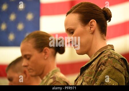 Le Lieutenant-colonel de l'US Air Force Marietta Sanders et la partie officielle y compris au départ 380e Escadron de soutien de la Force expéditionnaire du lieutenant-colonel commandant Kimberly Jennings et le Colonel Eric Fajardo commander 380e Escadre expéditionnaire de la Groupe de soutien de mission participer à une cérémonie de passation de commandement à l'intérieur du centre fantôme, Al Dhafra Air Base, Emirats Arabes Unis, le 23 mai 2018. Banque D'Images