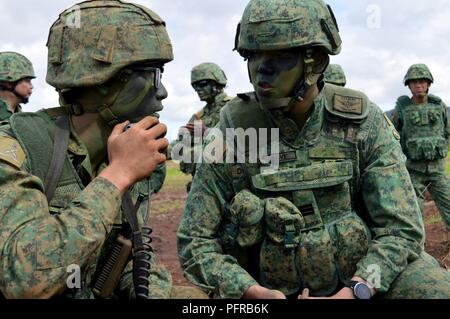 Le capitaine Dave Koh (à droite), une mission d'observation de la grève (tempête), membre de l'équipe de l'Armée de Singapour s'adresse à un subordonné au cours d'un exercice de tir réel pour Tiger Balm 18 à Schofield Barracks, Missouri, le 24 mai 2018. Tiger Balm est un exercice bilatéral sont tenus annuellement entre les États-Unis et Singapour armées. Banque D'Images