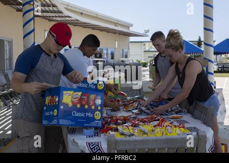 Les organismes de services aux bénévoles mis en place la nourriture pour l'Kinser Block Party le 25 mai 2018, à l'USO, Camp Kinser, Okinawa, Japon. L'Kinser Block Party a été réalisé par le colonel du Corps des Marines américain Scott R. Johnson, le commandant du camp pour le Camp Kinser, comme un moyen pour les militaires et leur famille pour profiter d'une journée de plaisir et de camaraderie avant de se lancer dans le week-end du Memorial Day. Au cours de la période de cinq heures d'événements, les participants ont profité de la nourriture gratuite, des jeux, de la musique live et une cuve d'immersion. Banque D'Images