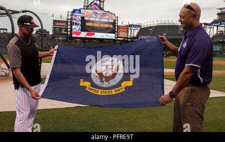 Chef principal de la Marine américaine David Mills (à droite) présente un drapeau de la Marine américaine à Colorado Rockies pitcher Mike Dunn, pendant les match à Denver, Colorado, le 28 mai 2018. Mills est une équipe du ministère de la Défense 2018 Athlète de la Marine qui seront en compétition dans le champ de tir, tir à l'ARC, et de basket-ball en fauteuil roulant pendant le Guerrier Juin 1-9, 2018 Jeux. Banque D'Images