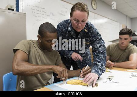 Le cmdr. Cheryl Varner (centre), un médecin de l'établissement médical expéditionnaire dans les Grands Lacs Grands Lacs, Ill., indique le Sergent de l'armée. Yakini Moseley (à gauche), une infirmière de l'Hôpital de soutien au combat 75e à Atlanta, GA, lors de la suture de la formation au bien-être de la formation innovante de l'Alabama (IRT) Mission 29 Mai, 2018 à Monroe County High School de Monroeville, Ala. l'IRT vous permet de bénéficier des possibilités de formation pour les soldats, aviateurs et marins participant à la mission. (Garde nationale aérienne des États-Unis Banque D'Images