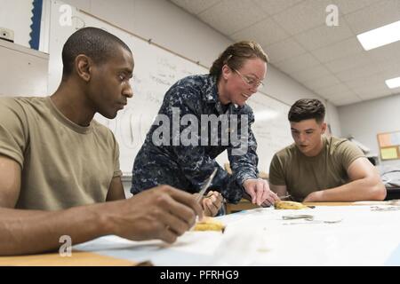 Le cmdr. Cheryl Varner (centre), un médecin de l'établissement médical expéditionnaire dans les Grands Lacs Grands Lacs, Ill., démontre la suture tandis que le sergent de l'armée. Yakini Moseley (à gauche), une infirmière de l'Hôpital de soutien au combat 75e (CSH) à Atlanta, GA, et la CPS. Hunter Myers (à droite), un infirmier de la 75e CSH à Tuscaloosa, AL, d'observer à la formation préparatoire à l'innovation Bien-être de l'Alabama (IRT) Mission 29 Mai, 2018 à Monroe County High School de Monroeville, Ala. l'IRT vous permet de bénéficier des possibilités de formation pour les soldats, aviateurs et marins participant à la mission. (Garde nationale aérienne des États-Unis Banque D'Images