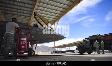 Armestead-Williams Senior Airman Ocare, 57e Escadron de maintenance des aéronefs de l'Unité de maintenance d'aéronefs de la foudre sous-chef d'équipe dédiée, d'un membre de la 1re classe Lee Maynard, 99e Escadron de préparation logistique de distribution de carburants, de l'opérateur et le sergent. Sara Vogt, 99 LRS fossiles superviseur distribution, ravitailler un F-35 Lightning II chasse affecté à la 6e Escadron d'armes à Nellis Air Force Base, au Nevada, le 29 mai 2018. Le WPS 6 participe à la finale de la Coupe Stanley 2 Jeu flyover. Banque D'Images