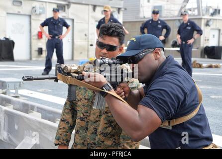 La mer de Sulu (30 mai 2018) Musicien marine 1re classe Vincent Moody, droit, attribué aux 7e Flotte, reçoit sur le tir réel M-4 fusil semi-automatique de Cpl. Gurpreet Singh, affectés à la lutte contre le terrorisme de la Flotte du Pacifique de l'équipe de sécurité (FASTPAC) marines à bord de l'USNS Millinocket (T-EPF) 3. Plus de 60 marins et Marines à partir de la 7ème Flotte américaine personnel sont actuellement engagés dans Ludlow dans le cadre de la 7ème flotte américaine de coopération en matière de sécurité dans le théâtre (TSC) et de patrouille va visiter plusieurs pays de l'Indo-Pacifique dans les semaines à venir. Banque D'Images