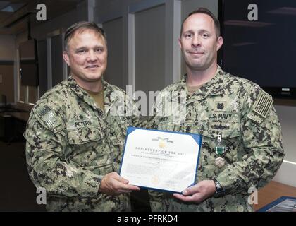 PANAMA CITY, Floride - Naval Surface Warfare Center Panama City (CDSN PCD)COMMANDANT Le Capitaine Aaron Peters, USN, gauche, félicite le chef plongeur de la marine américaine (DSW/EXW/SW) Taylor Arney, USN, droite, sur réception de la Navy et du Marine Corps médaille pour sa médaille du service tout en servant de recherche, de développement, d'essai et l'évaluation des opérations de plongée et sous-chef de production à CDSN PCD. Eddie Green Banque D'Images