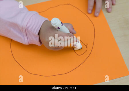 Girl drawing visage avec feutre Banque D'Images
