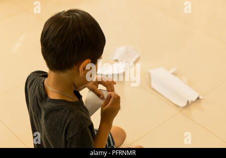 Petit garçon faire paper plane Banque D'Images