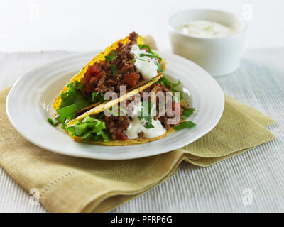 Tacos au boeuf sur une assiette, avec de la crème Banque D'Images