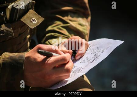 La FPC. Romain Yadiel, Buffalo, New York, natif de fantassin avec 1er Escadron, 2e régiment de cavalerie, enregistre les informations d'un Nine-Line pendant le combat MEDEVAC gareautrain avec formation de groupe de combat à la Pologne Bemowo Piskie Domaine de formation, Pologne, le 31 mai 2018. La Pologne est un groupe de combat, unique coalition multinationale d'États-Unis, Royaume-Uni, croate et soldats roumains qui servent avec la 15e Brigade mécanisée polonaise comme une force de dissuasion de l'OTAN à l'appui de l'amélioration de l'avant la Présence. Banque D'Images