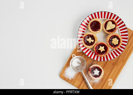Tartelettes à la confiture de la plaque sur une planche en bois Banque D'Images