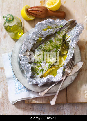 Psari fourni ladolemono, poisson cuit dans du papier d'aluminium avec le citron, le fenouil et l'huile d'olive Banque D'Images
