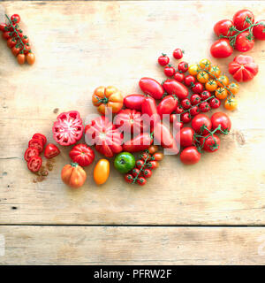 Une sélection de tomates de différentes formes, tailles, et couleurs sur fond de bois Banque D'Images