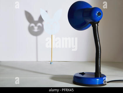 Lampe de table bleu jette une ombre d'un masque rabit Banque D'Images