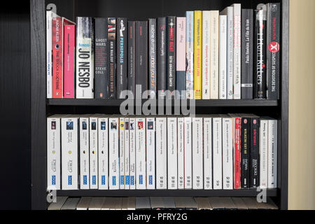 Un gros plan des étagères de la maison remplies d'un mélange de livres français et anglais, une collection littéraire diversifiée et bilingue et une bibliothèque à domicile organisée Banque D'Images