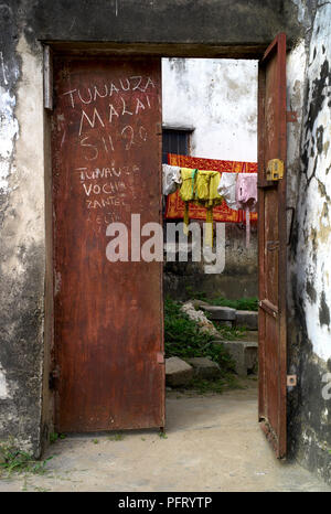 Pittoresque Rusty Vintage Steel Door, Stone Town, Zanzibar; traduction de texte sur la porte: "Nous vendons une couverture - Sh[illing] 20[000]" Banque D'Images