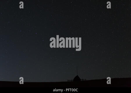 Silhouette d'une pile de paille contre le ciel de nuit avec les étoiles et la Voie lactée visible Banque D'Images