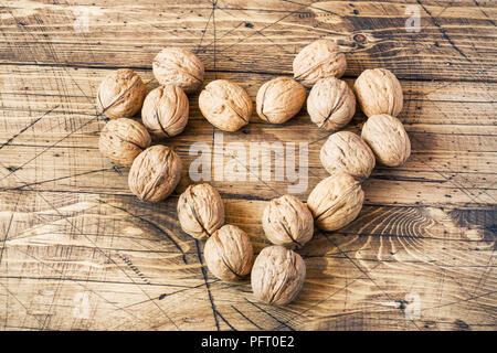 Les noix en forme de coeur sur fond de bois vintage foncé. Noyer en bonne santé nutrition. Banque D'Images