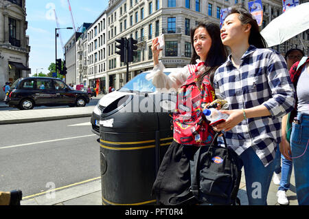 Les touristes asiatiques dans Regent Street, Londres, Angleterre, Royaume-Uni. Banque D'Images