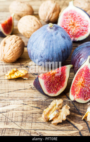 Figues fraîches ensemble et couper avec les cerneaux de noix sur un fond en bois ancien Banque D'Images