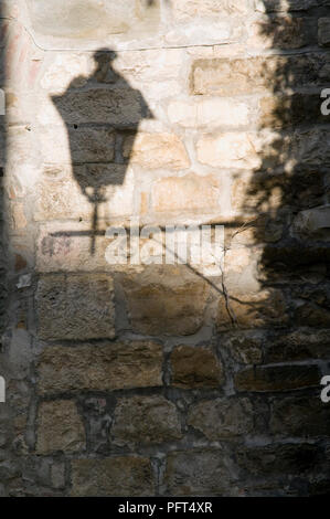 Italie, Toscane, Montefioralle, ombre de lampe de rue sur mur de pierre Banque D'Images
