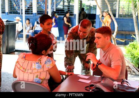 La CPS. Alec Erhard (droite), combattre pour le medic 477th Medical Company (Ambulance), et le major Edward Orellana, un linguiste de la 141e bataillon de renseignement militaire et dont les parents sont originaires d'El Salvador, tous deux attachés à la Force opérationnelle interarmées - espoir, de communiquer avec les ressortissants locaux au cours d'un exercice d'entraînement de préparation médicale dans le canton d'Espino Abajo dans le cadre de au-delà de l'horizon 2018 le 29 mai. BTH est un rapport annuel de l'armée des États-Unis et du sud du Commandement Sud des États-Unis et le programme d'aide humanitaire civique exercice déployant l'Armée active, Garde nationale et des soldats de la réserve s'alongsi Banque D'Images