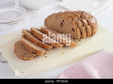 Tranches de noisette, pain de seigle et rasin sur planche à découper avec des plaques et nappes Banque D'Images