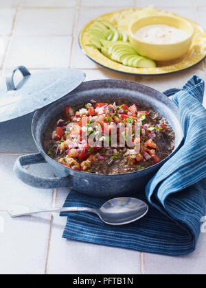 Les haricots frits garnis de tomates fraîches, oignons et fines herbes (salsa) pico de gallo Banque D'Images