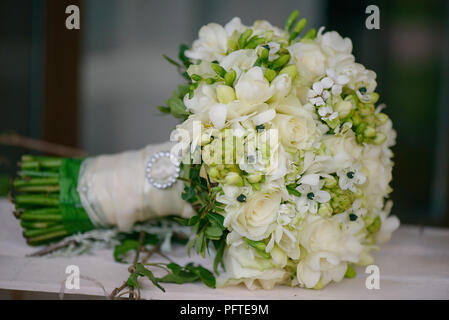 Vue latérale d'un bouquet de mariage avec des roses ivoire, blanc freesia, fleurs stephanotis mélangé avec de la verdure et de fleurs sauvages Banque D'Images