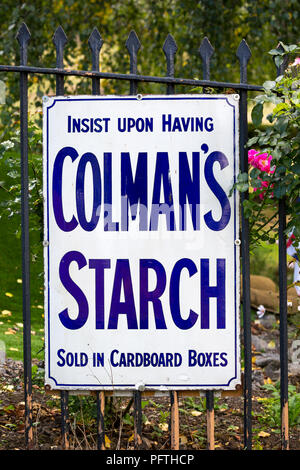 Affiche vintage pour l'amidon de Colman, enseigne publicitaire en émail blanc sur les rambardes extérieures de la gare du patrimoine britannique. Banque D'Images