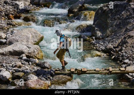 Alors que le passage de la rivière trekking du village de noyer Arslanbob, Kirghizistan Banque D'Images