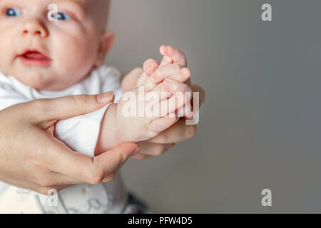 Jeune mère et nouveau-né de l'applaudir leurs mains. Femme et enfant nouveau né garçon se détendre et jouer sur fond blanc. La famille, la maternité, la tendresse, p Banque D'Images