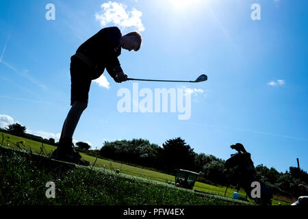 Jeune adolescent prenant une balançoire à une balle de golf pour la première fois. Banque D'Images