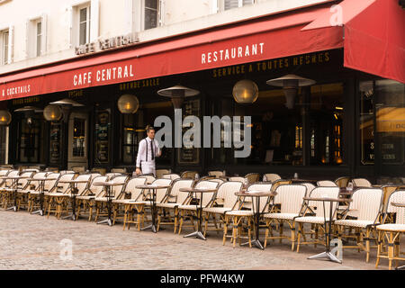 Paris serveur - Un serveur parisien définit les tableaux au Cafe Restaurant Central sur la Rue Cler à Paris, France, Europe. Banque D'Images