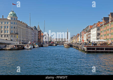 Vue à travers le canal de Nyhavn vintage avec les navires et les maisons colorées à Kongens Nytorv à Copenhague. Bars et restaurants bondés et navires vintage Banque D'Images