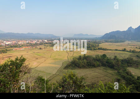 Belle vue de la ville de Vang Vieng et les champs et les montagnes de calcaire karstique d'en haut près de la province de Vientiane, Vang Vieng, Laos, lors d'une journée ensoleillée. Banque D'Images