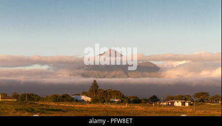 Le Mont Taranaki émerge des nuages. L'une des scènes classiques capturé au coucher du soleil de la liberté Camping Park à Opunake Beach Banque D'Images