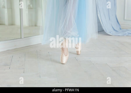 Belles jambes de jeune ballerine qui met sur les pointes à l'étage en bois blanc, arrière-plan, Vue de dessus du dessus avec copie espace. La pratique de ballet. Bea Banque D'Images