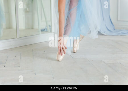 Belles jambes de jeune ballerine qui met sur les pointes à l'étage en bois blanc, arrière-plan, Vue de dessus du dessus avec copie espace. La pratique de ballet. Bea Banque D'Images