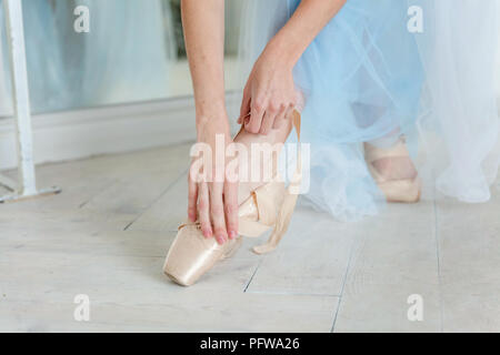 Belles jambes de jeune ballerine qui met sur les pointes à l'étage en bois blanc, arrière-plan, Vue de dessus du dessus avec copie espace. La pratique de ballet. Bea Banque D'Images