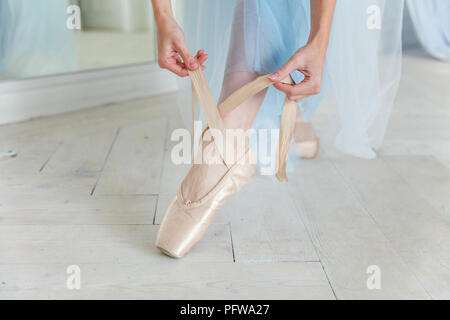 Belles jambes de jeune ballerine qui met sur les pointes à l'étage en bois blanc, arrière-plan, Vue de dessus du dessus avec copie espace. La pratique de ballet. Bea Banque D'Images